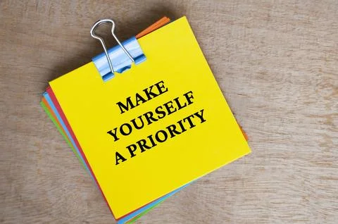 Make yourself a priority text on yellow notepad. Motivational concept. Stock Photos