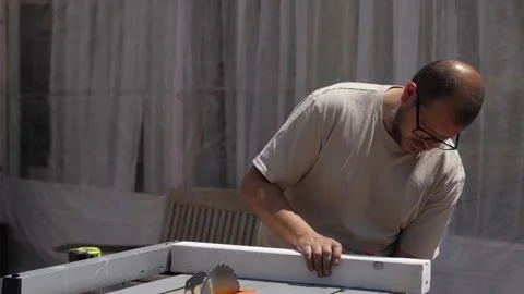 Maker gently aligns wood before cutting, embodying patience and purpose Stock Footage 308017776