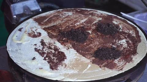 Makes a crepe pancake on a baking tray in a creperie, give chocolate topping Vidéo 204048843