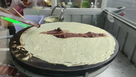 Makes a crepe pancake on a baking tray in a creperie, give chocolate topping 스톡 동영상 218172802