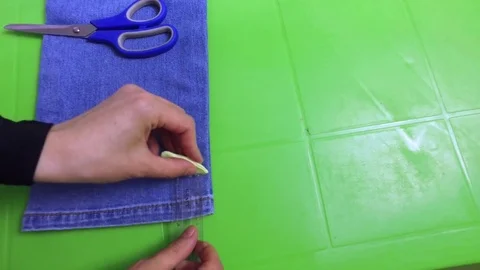 Makes marks on jeans and cuts off with scissors Stock Footage 79632242