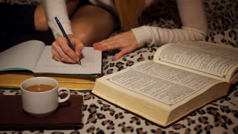 Makes notes in a notebook from the book Stock Footage 85897789