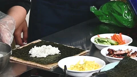 Makes sushi and rolls from rice, red fish and cream cheese Stock Footage 236903676