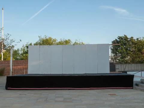 Makeshift empty outdoor stage with white wall Stock Photos