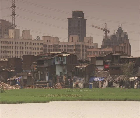 Makeshift homes in Mumbai slums, pan to apartment buildings Stock Footage 86741716