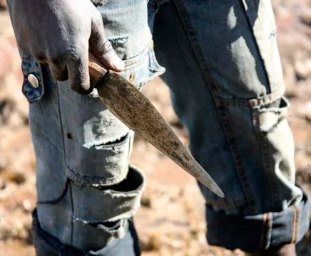 Makeshift primitive knife in the hand of a dark-skinned man Stock Photos