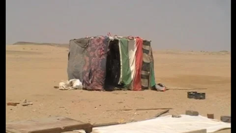 Makeshift shack draped with colorful blankets in the desert Stock Footage 346146791