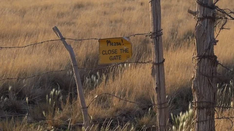 A makeshift wire fence gate on a ranch in the country Stock Footage 90662151