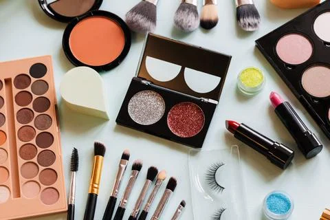 Makeup and brushes top view white table. Women workplace. Stock Photos
