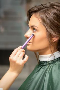 Makeup and hairstyle process. Makeup artist and hairdresser preparing young Stock Photos