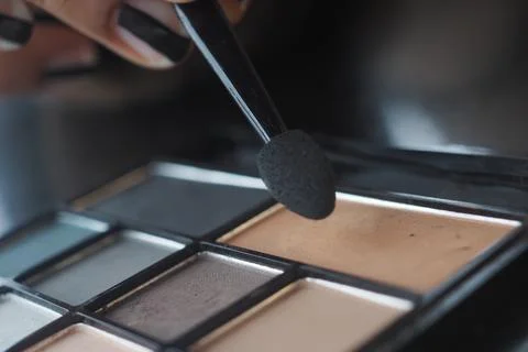 Makeup application with brush and palette on a table Foto stock
