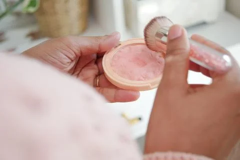 Makeup application with brush in a cozy room 库存照片