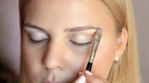 Makeup applied with a brush to the bright shade of mid-century model close plan Video stock 101650327