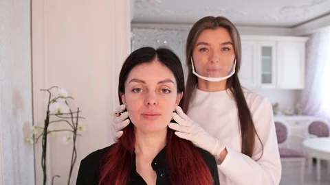Makeup artist and client look at the painted eyebrows in the mirror. Girls are Stock-Footage 106891931