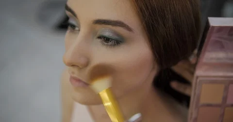 Makeup artist applies blusher on cheeks and nose closeup Stock Footage 124259965