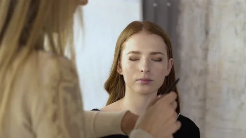 Makeup artist applies corrective shadows on the eyelids Stock Footage 99482294