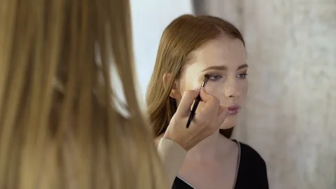 Makeup artist applies corrective shadows on the eyelids Stock Footage 99482318