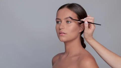Makeup artist applies eye shadow.The concept of aesthetic cosmetology Stock Footage 287837015