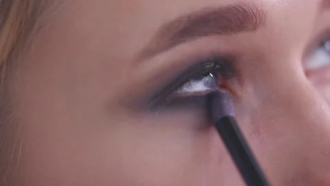 The makeup artist applies eyeshadow under the model's eyes Stock Footage 142135148
