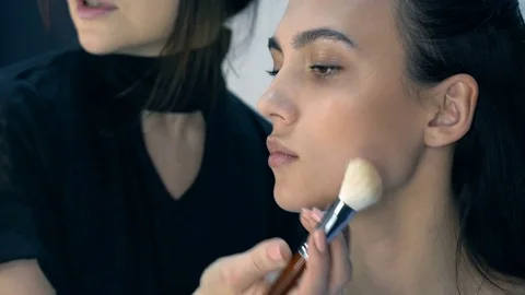 Makeup artist apply makeup to an attractive young women. Stock Footage 76138414