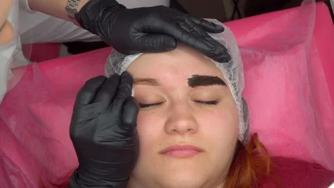 Makeup artist apply paint on client eyebrows close up. Concept makeup and Stock Footage 235944542