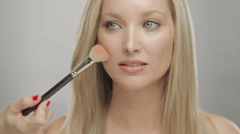 Makeup artist applying blush to cheek of woman Stock Footage 36189334