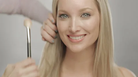 Makeup artist applying blush to cheek of woman Stock Footage 36194265
