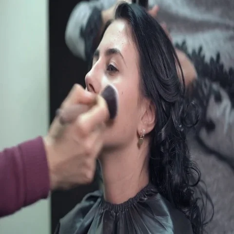 Makeup artist on applying blush on cheeks with powder brush Stock-Footage 69720580