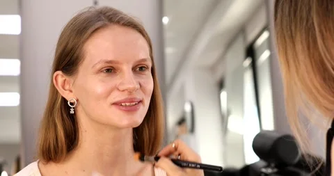 Makeup artist applying blush on model. Make up. Stock Footage 303688693