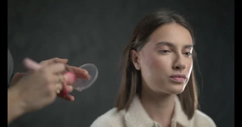Makeup Artist Applying Blush to a Models Cheeks in a Studio Setting Stock Footage 314349898