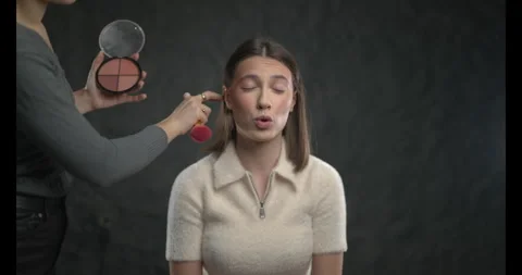 Makeup Artist Applying Blush to a Young Womans Cheeks, Creating a Radiant Look Stock Footage 316417101