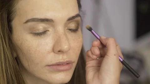 Makeup artist applying bronze shadows to beautiful model s eyelids 動画素材 82669432