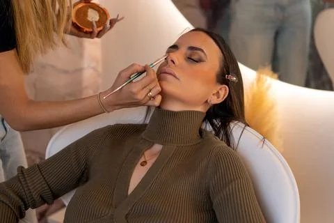 Makeup artist applying bronzer to client Stock Photos