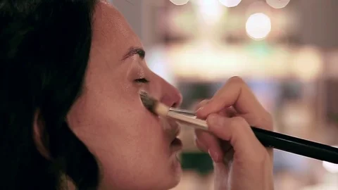 Makeup artist applying cosmetic tonal foundation on the face using brush Stock Footage 76081237