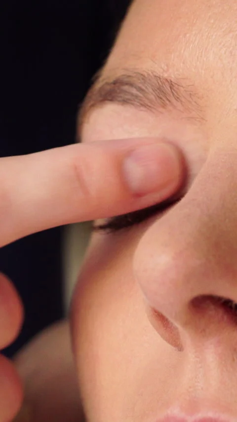 Makeup artist applying cream base to model eye. Vertical video Stock Footage 336430324