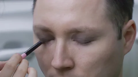 Makeup Artist Applying Dark Eyeshadow on a Man Video stock 330921361