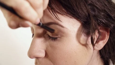 Makeup artist applying the eye shadows closeup Stock Footage 75382585