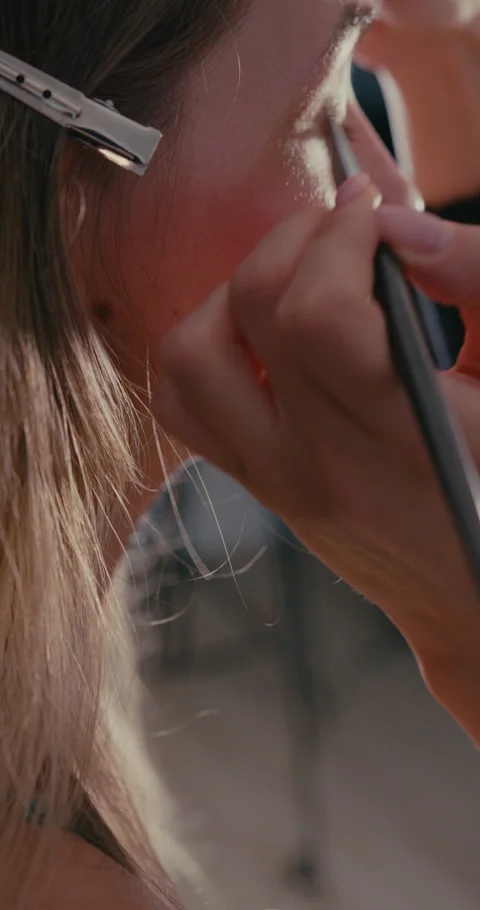 Makeup artist applying eyeshadow to a models face Stock-Footage 347010639