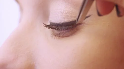 Makeup artist applying false eyelashes to model's eyes. Stock Footage 21894320