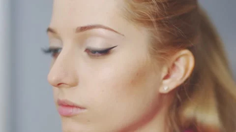 Makeup artist applying false eyelashes to model's eyes. Stock Footage 46635990
