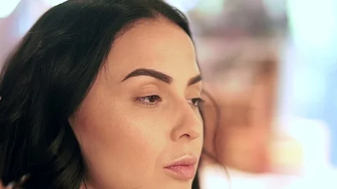 Makeup artist applying filling in eyebrows of a model with eyeshadows Stock Footage 76018692