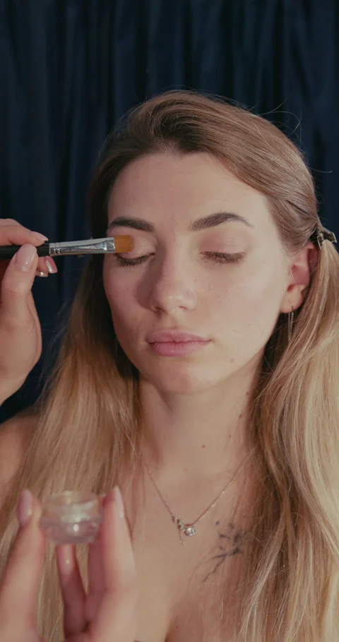 Makeup artist applying glitter eyeshadow on models eyelid Stock-Footage 347010849