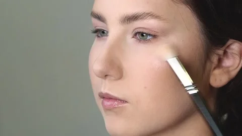 Makeup artist applying highlighter to model face Stock Footage 170381951