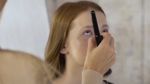 Makeup artist applying make-up on face of model Stock Footage 99482198