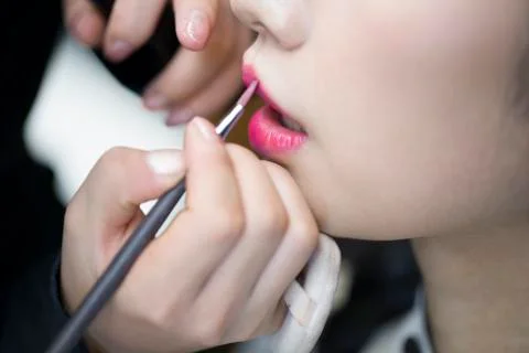 Makeup artist applying make-up to young woman Stock Photos