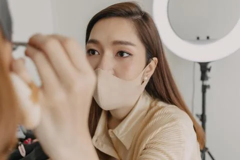 Makeup artist is applying makeup on client eyes. Stock Photos