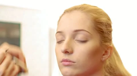 Makeup artist is applying makeup to model's eyebrows Stock-Footage 21262396