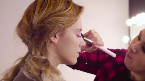 The makeup artist applying powder on the face Video stock 83415064