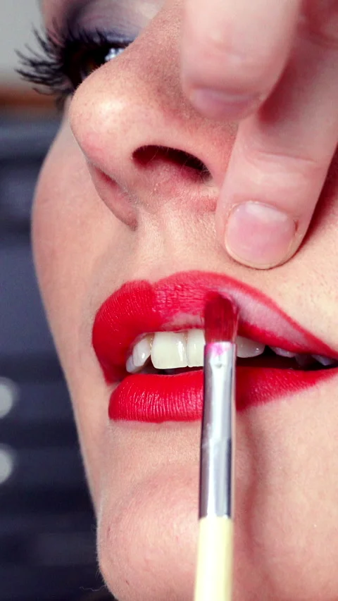 Makeup artist applying red lipstick to female lips. Vertical video Stock Footage 336428962