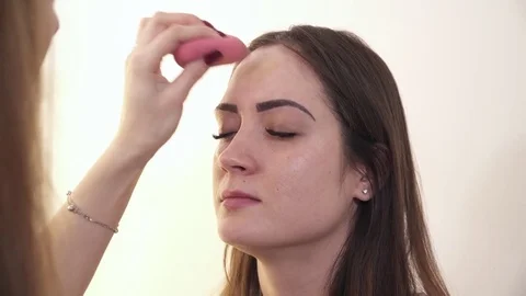 Makeup artist applying tone to a woman's face Stock Footage 73568720